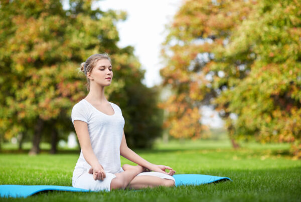 Mulher praticando yoga para aliviar o estresse crônico