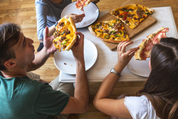 Casal comendo fast food, um dos fatores que mais prejudicam o emgrecimento